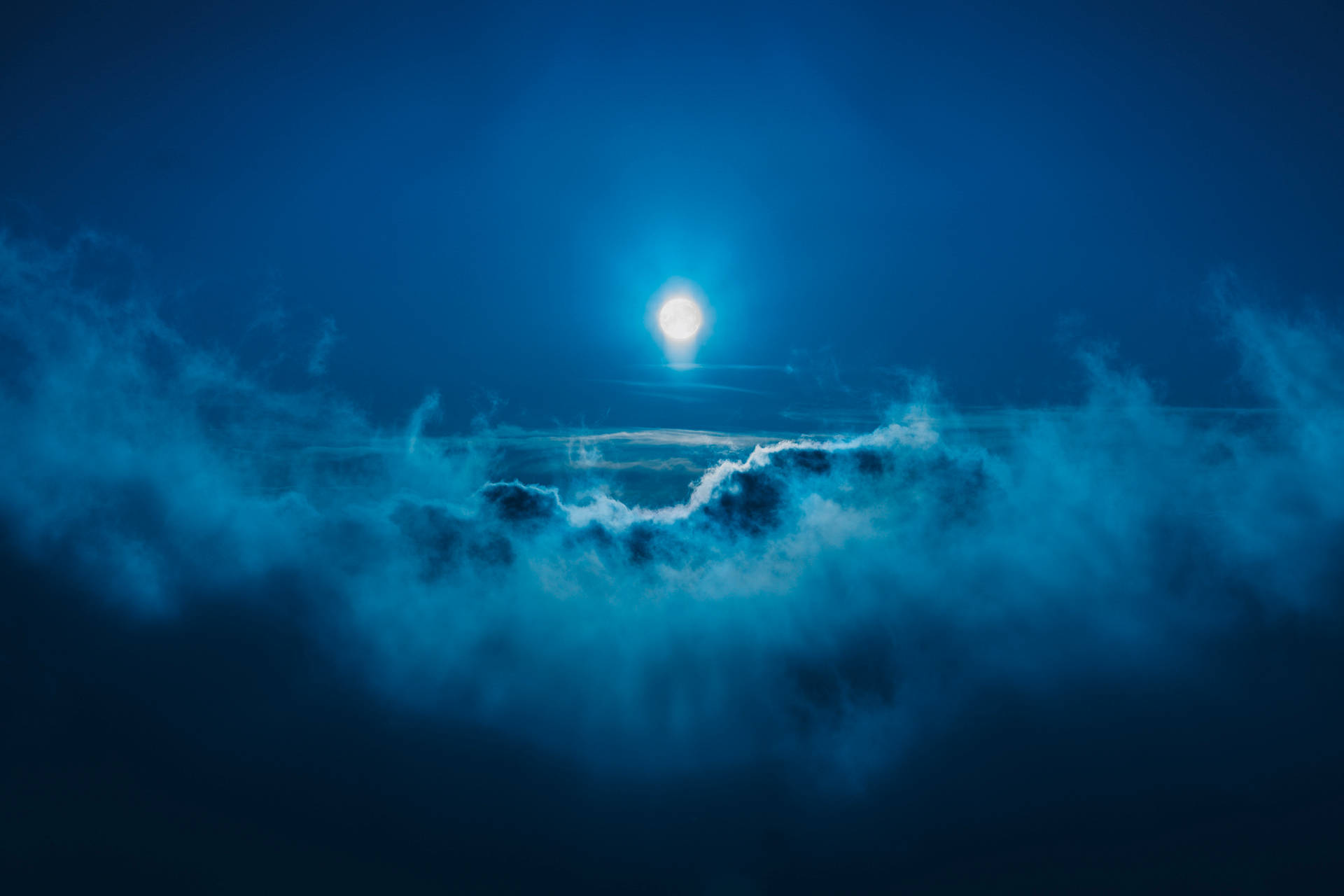 Full Moon Among Dark Blue Clouds Background