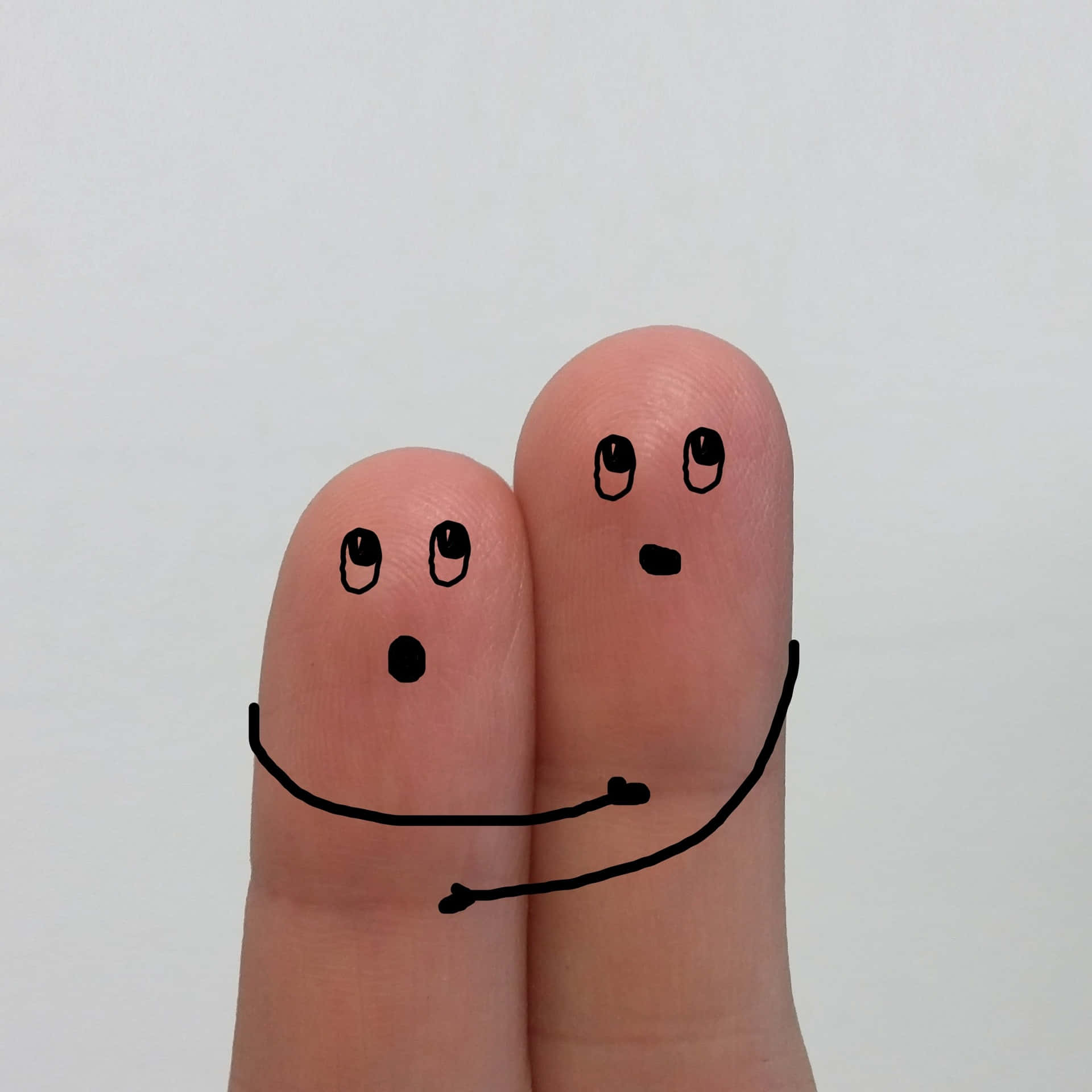 Funny Photo Of Two Tangible Fingers With Faces And Arms Drawn Background