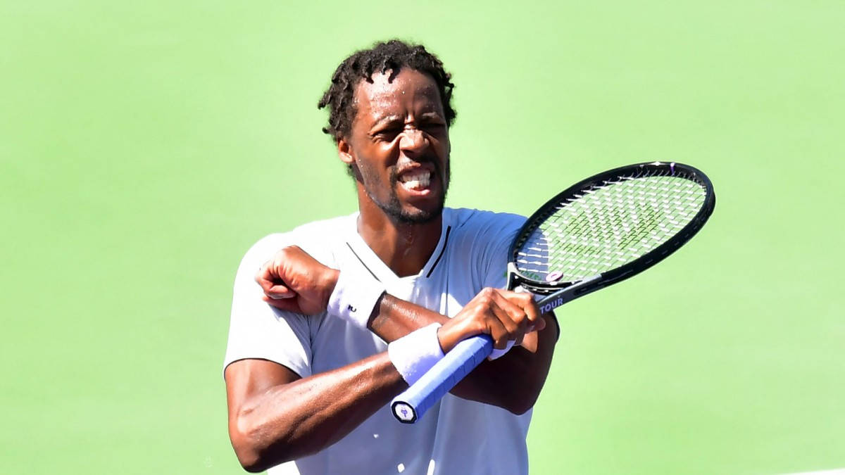 Gael Monfils In Focused Action Against A Green Background Background