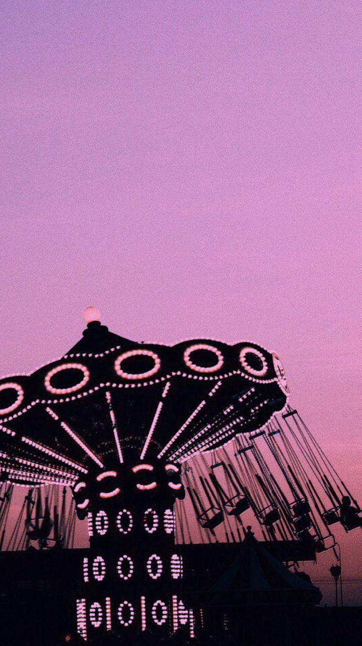 Gambar Swing Ride Under Pink Sky Background