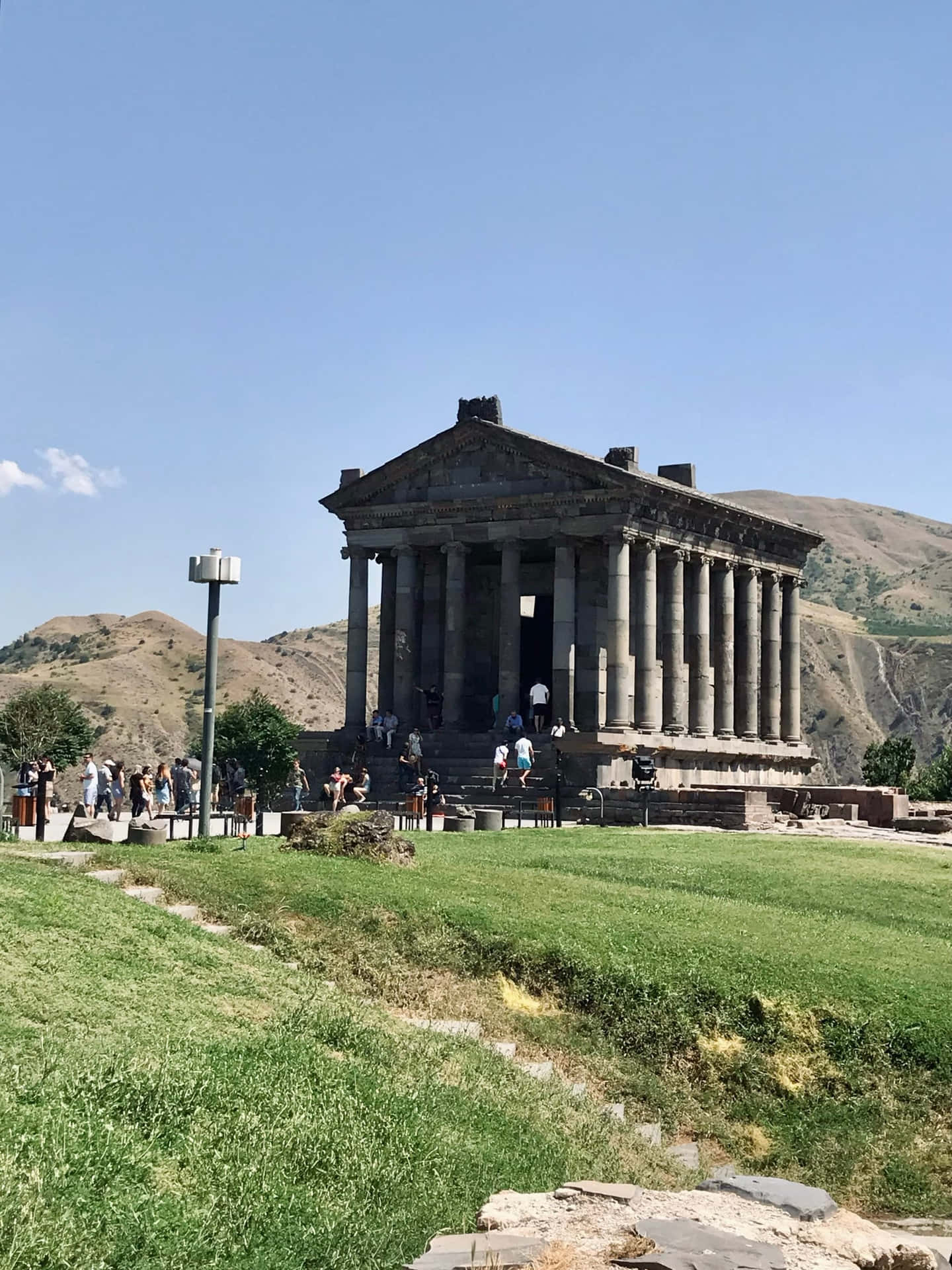 Garni Temple With Tourists On Walkway Background