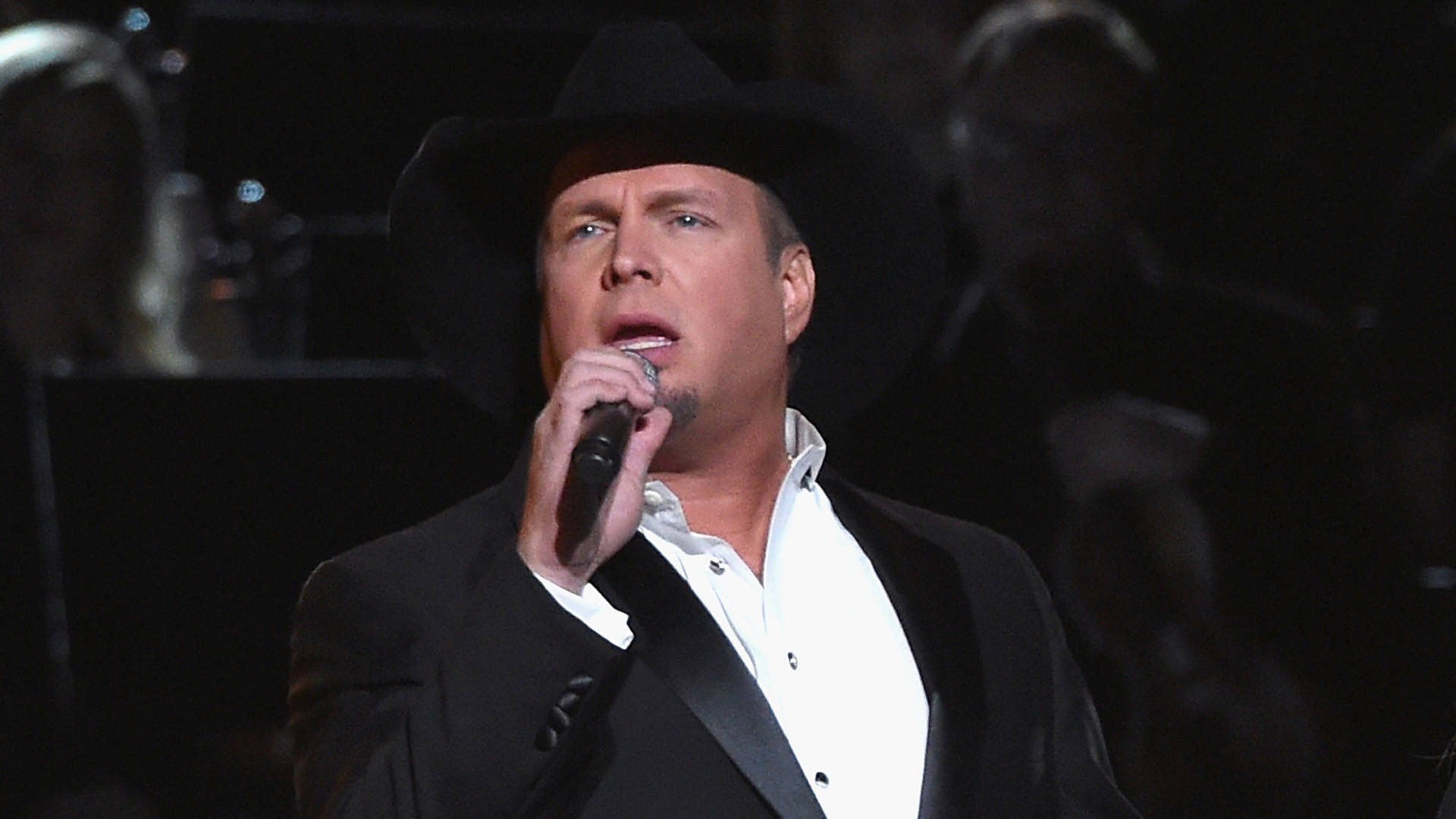 Garth Brooks Holding A Microphone Background