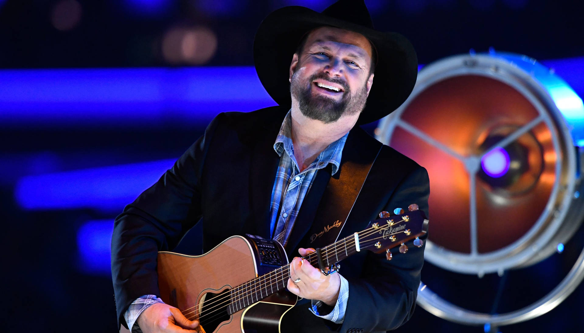 Garth Brooks Illuminating The Stage With His Electrifying Performance Background