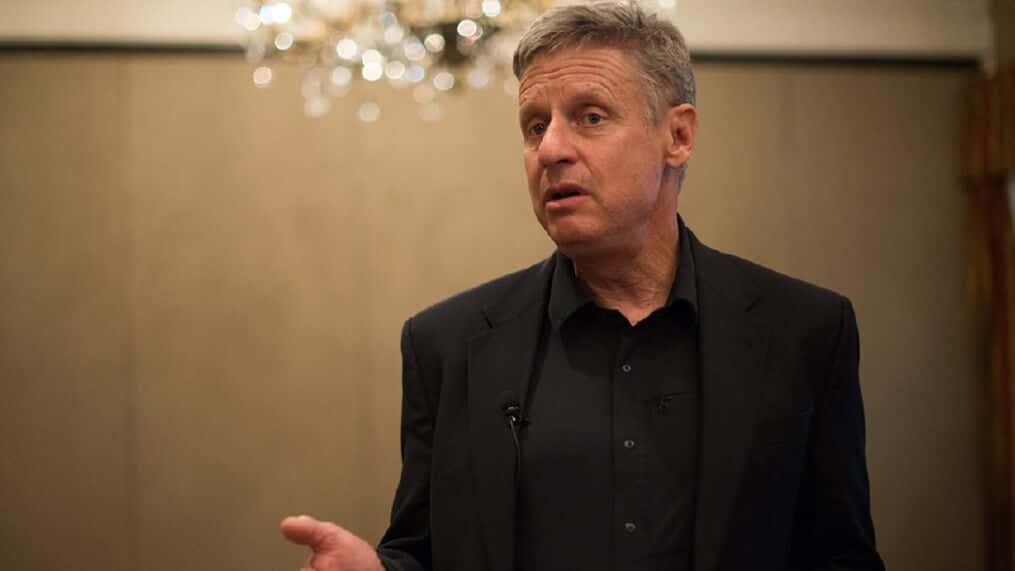 Gary Johnson In Black With A Brown Backdrop Background