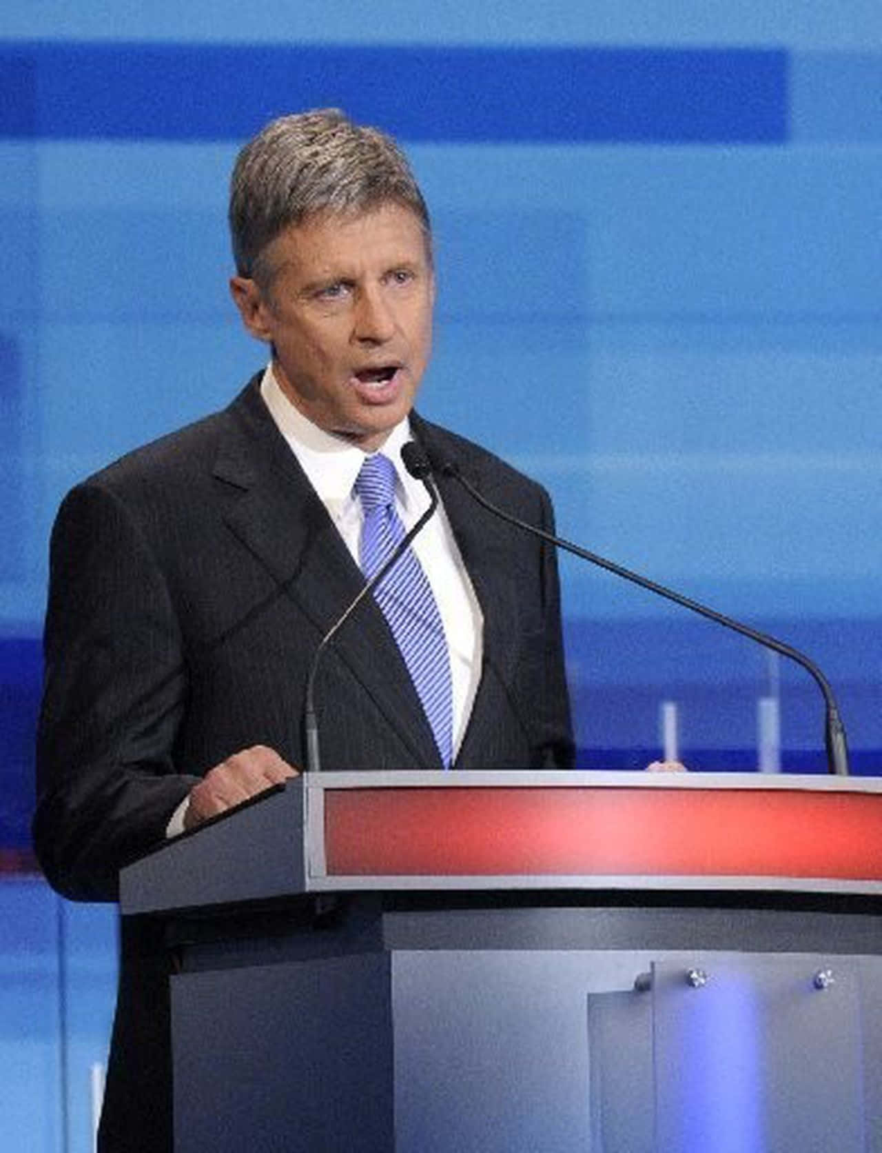 Gary Johnson Speaking Into A Blue Microphone Background