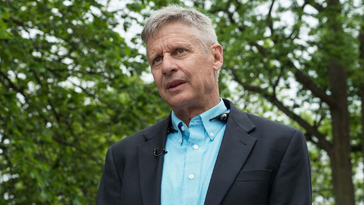 Gary Johnson Wearing Blue Shirt With Black Suit Background