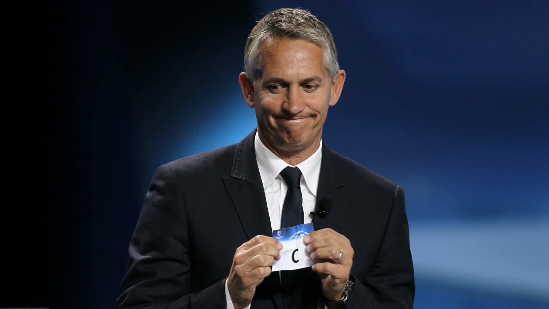 Gary Lineker, Eloquent Football Broadcaster, Delivering A Presentation On Stage. Background
