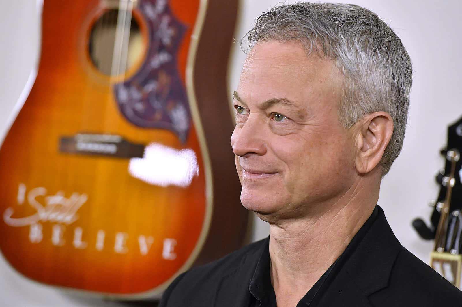 Gary Sinise Side Profilewith Guitar Background Background