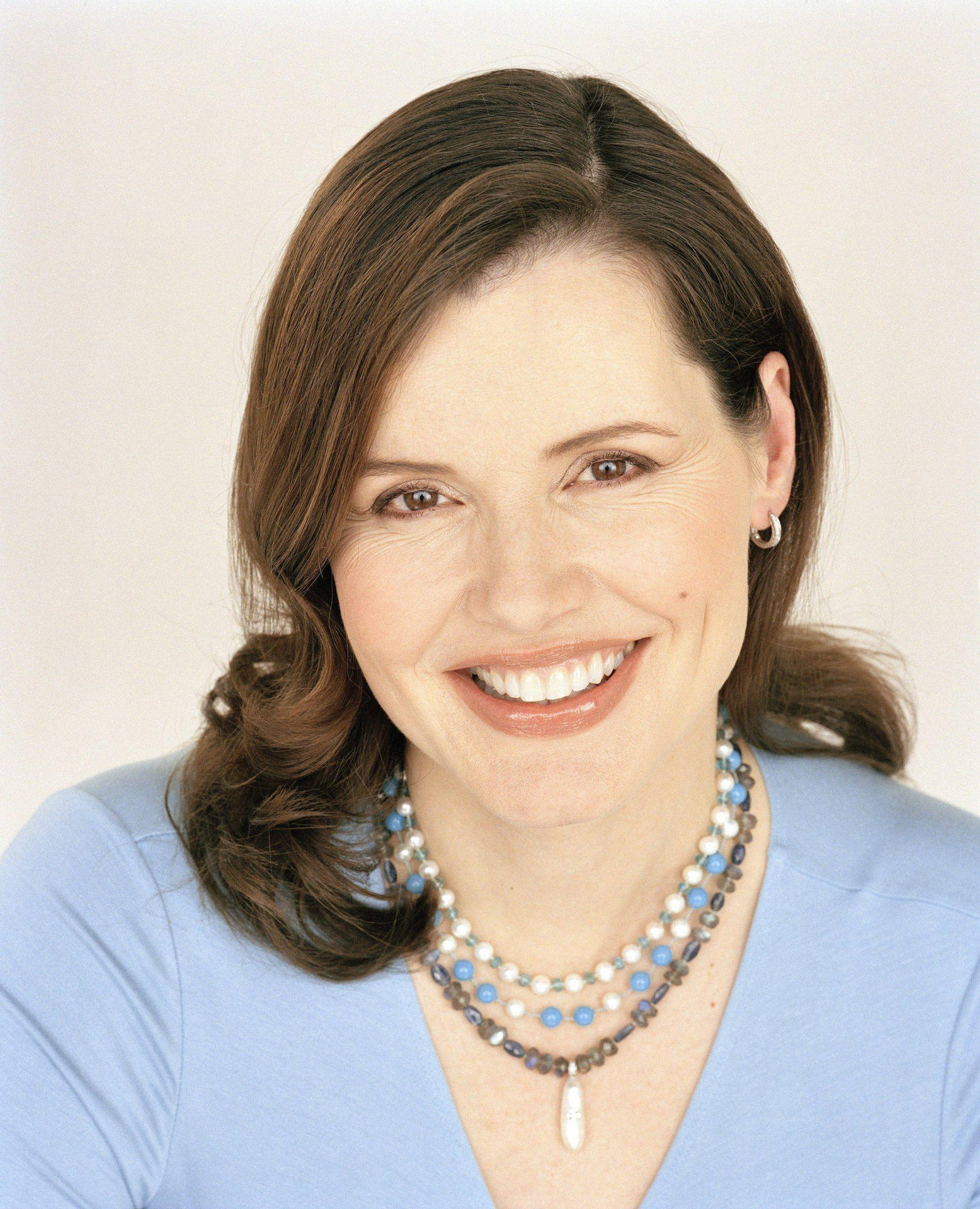 Geena Davis Glowing In Baby Blue Top Background