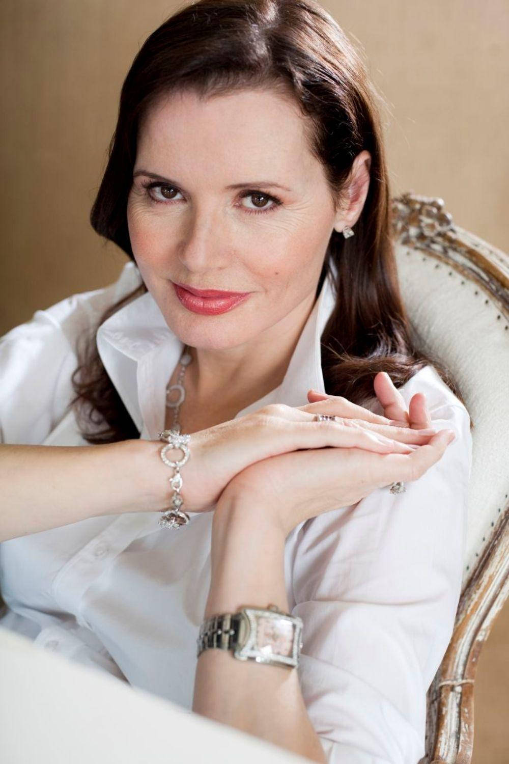 Geena Davis Wearing A Simplistic White Top Background