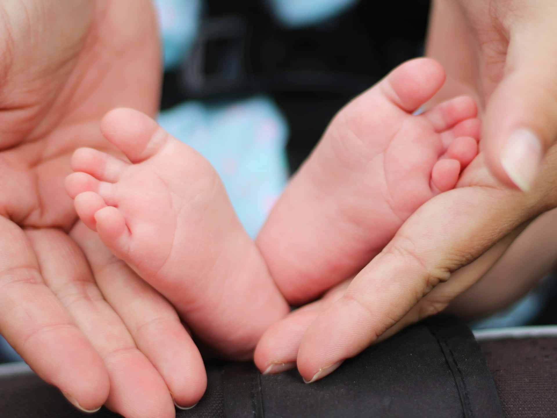 Gentle Holdof Baby Feet Background