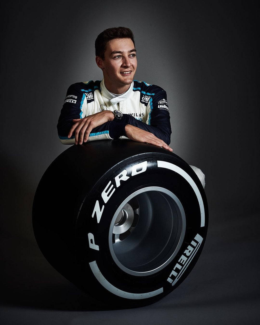 George Russel Leaning On Wheel Background