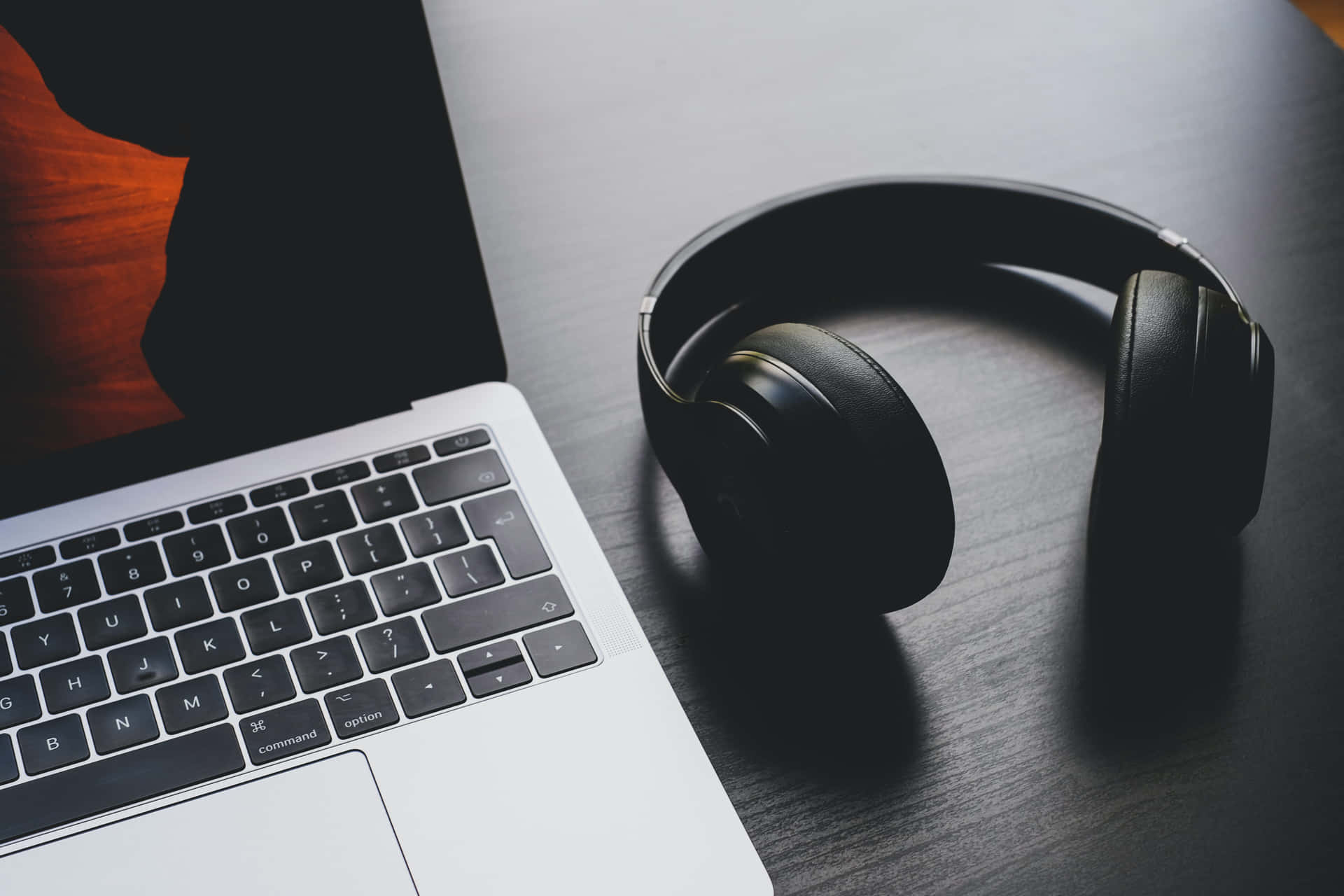Get Ready To Boost Your Music Listening With Headphones And Laptop Background