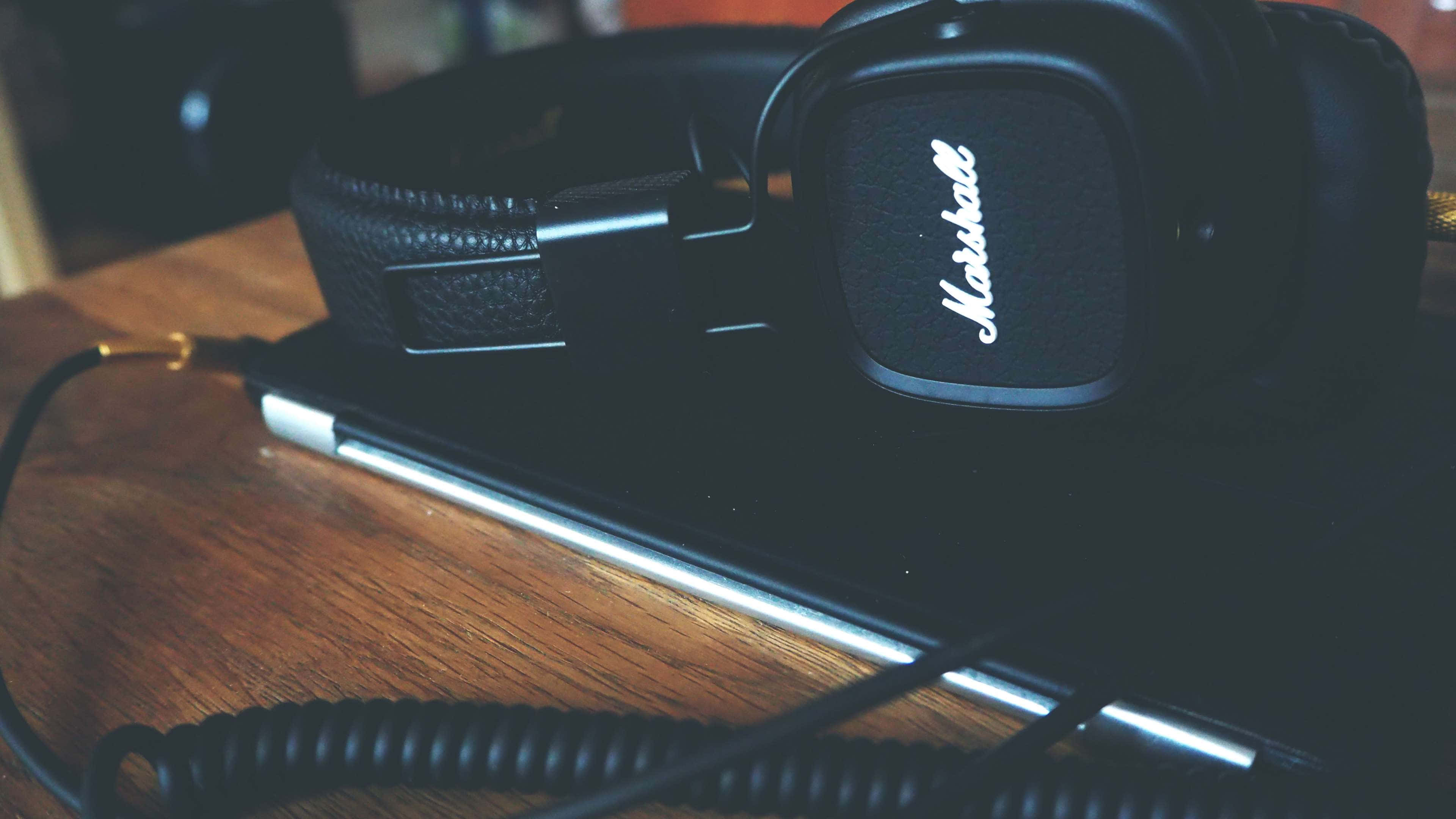 Get Things Done And Enjoy Your Music With A Laptop And Headphones Background