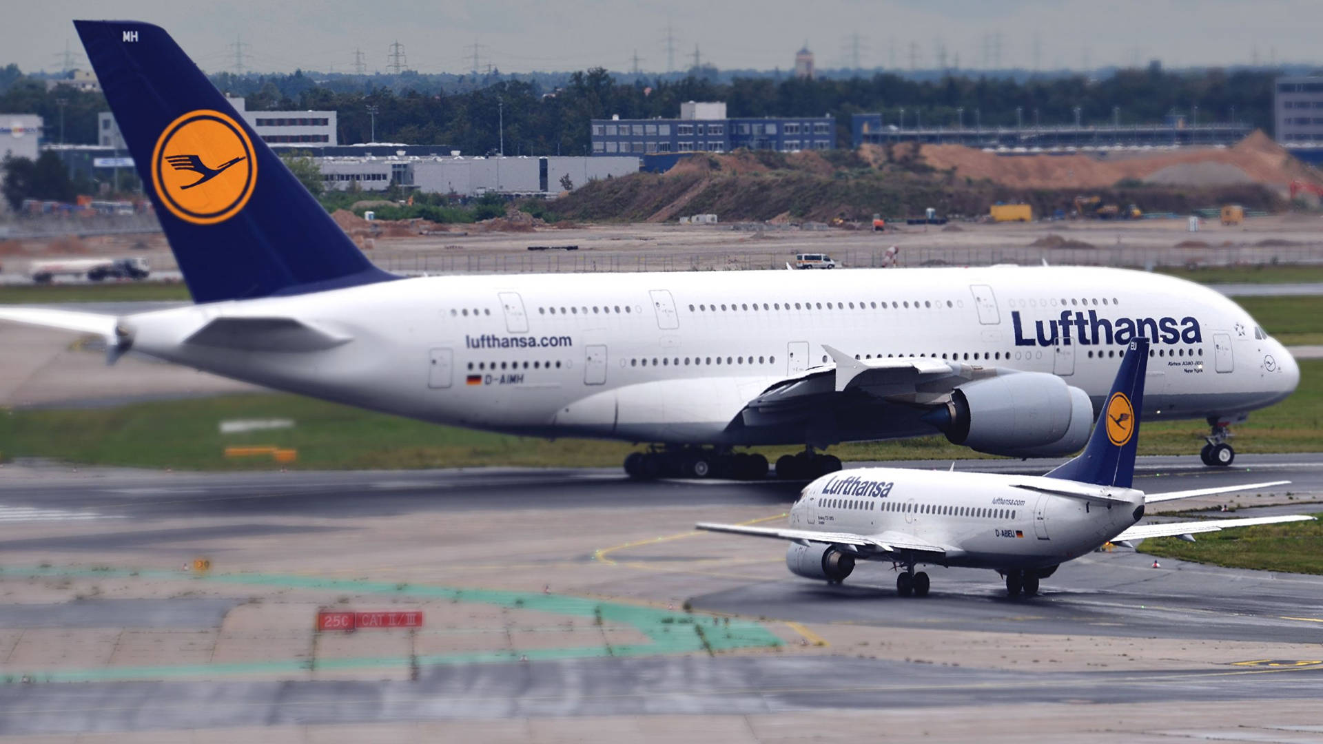 Giant And Mini Deutsche Lufthansa Airplanes Background