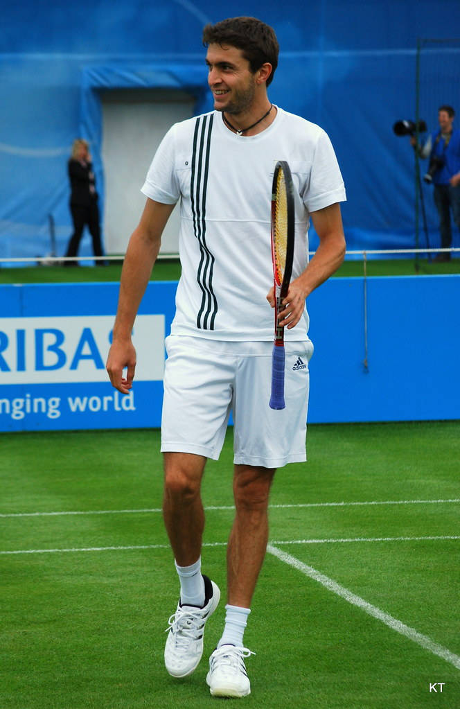 Gilles Simon In Action With His Signature Racket Background