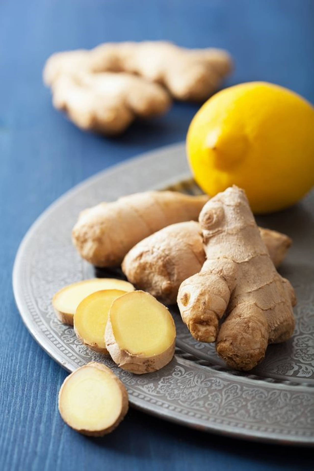 Ginger Roots Sliced And Lemon Background