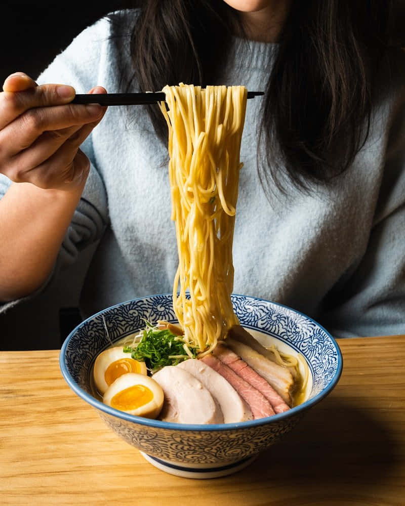 Girl Digging Out Ramen Noodles Background