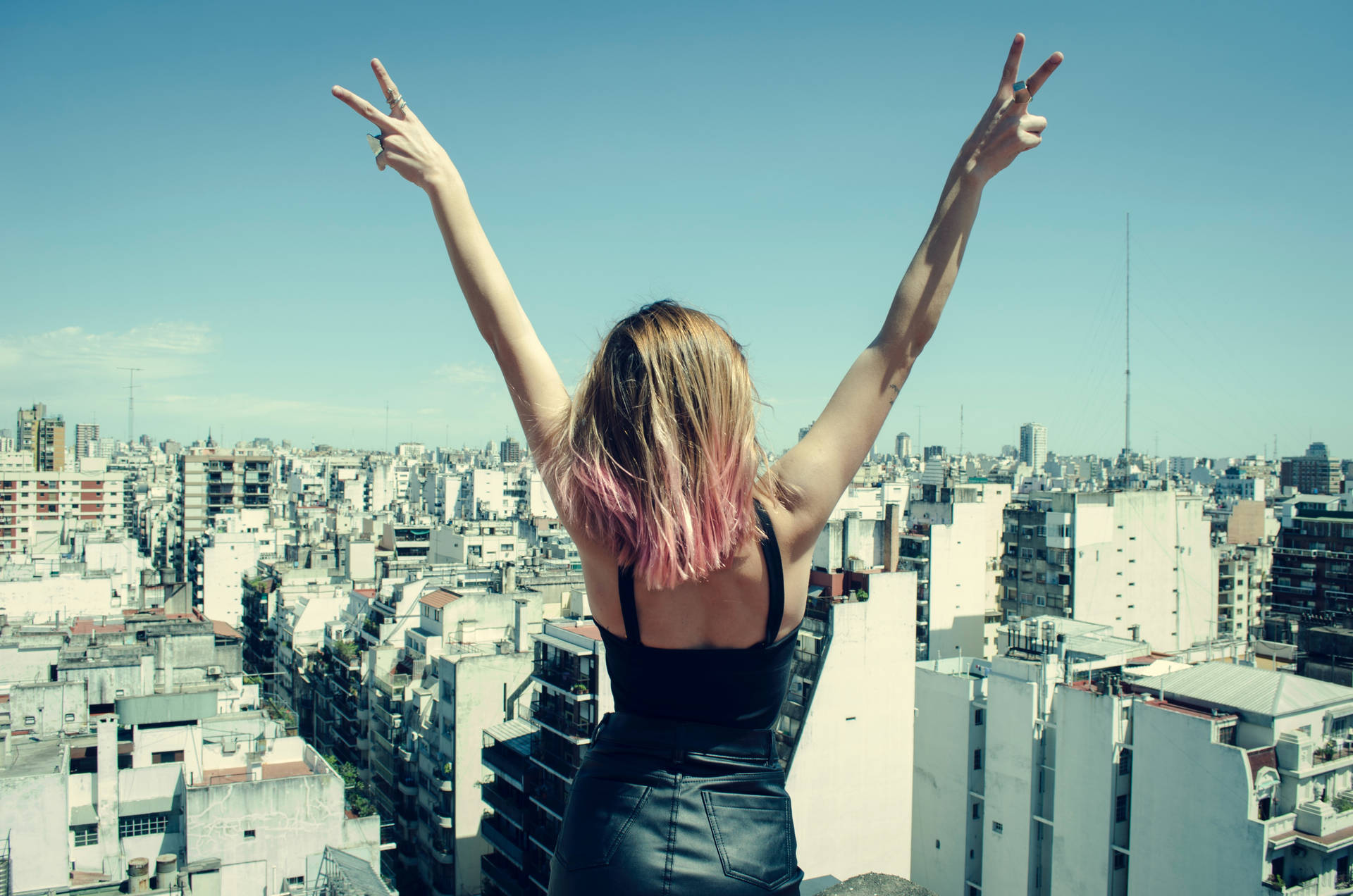 Girl Doing Hand Peace Symbol In City Background