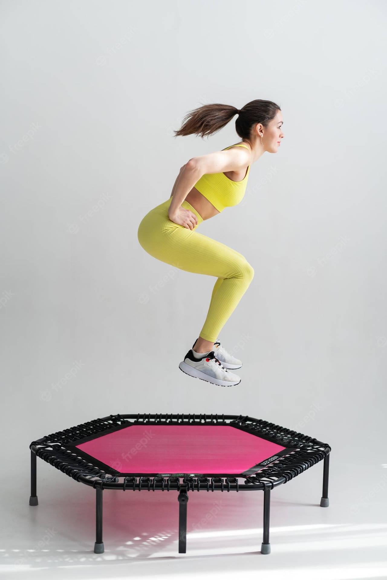 Girl Exercising On A Pink Hexagonal Trampoline Background