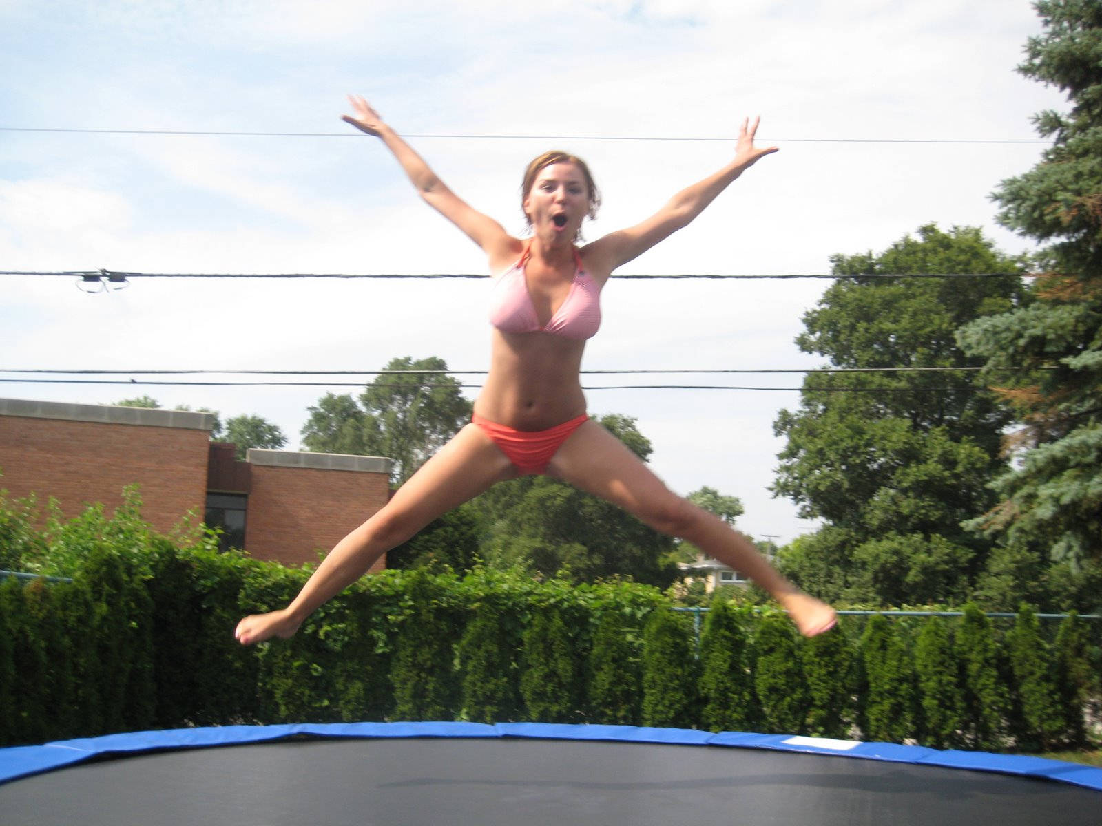 Girl In Bikini Jumping On A Trampoline