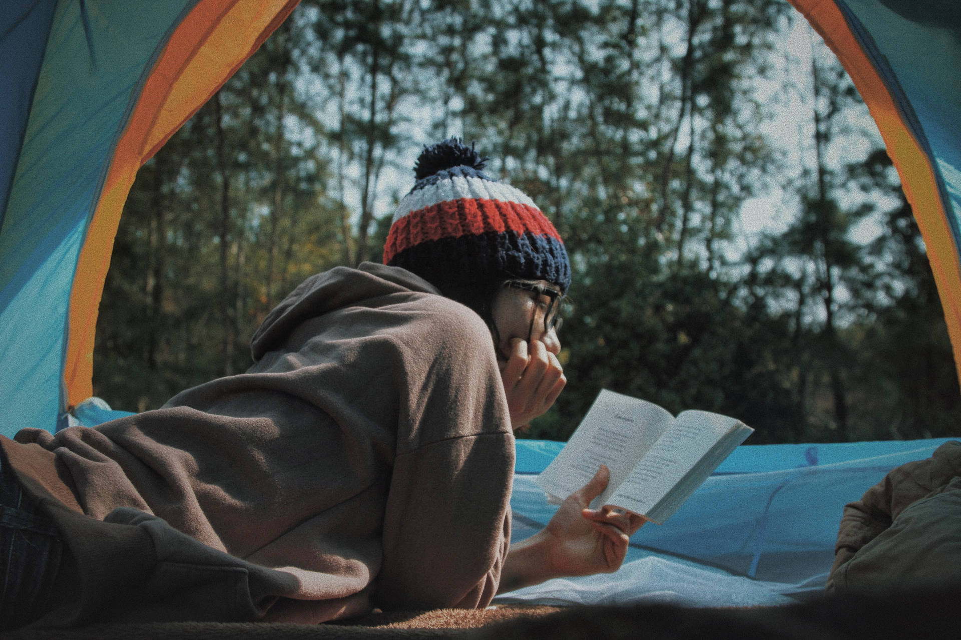 Girl Reading Book At Campsite Background