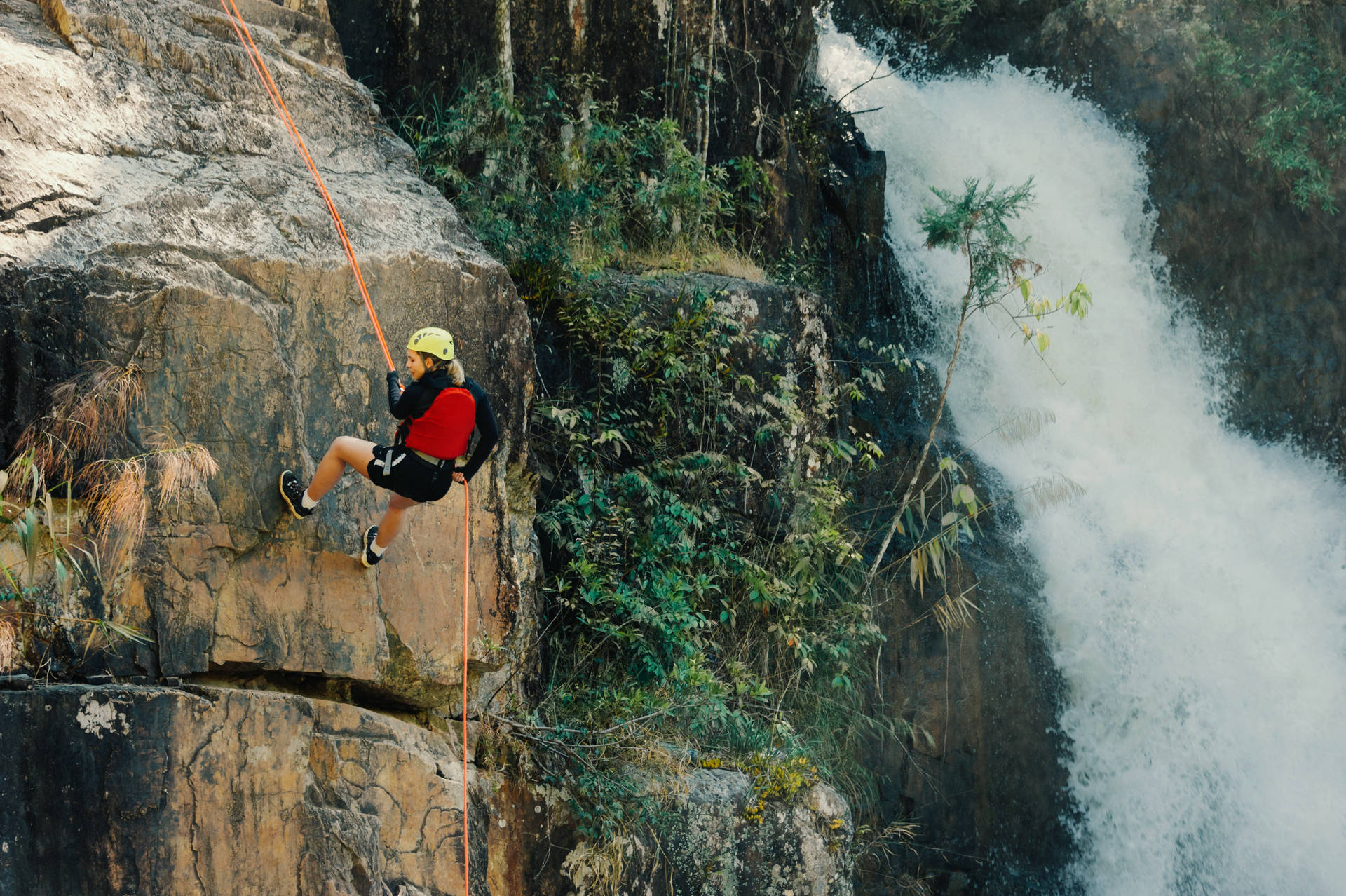 Girl Rock Climbing Near The Waterfalls