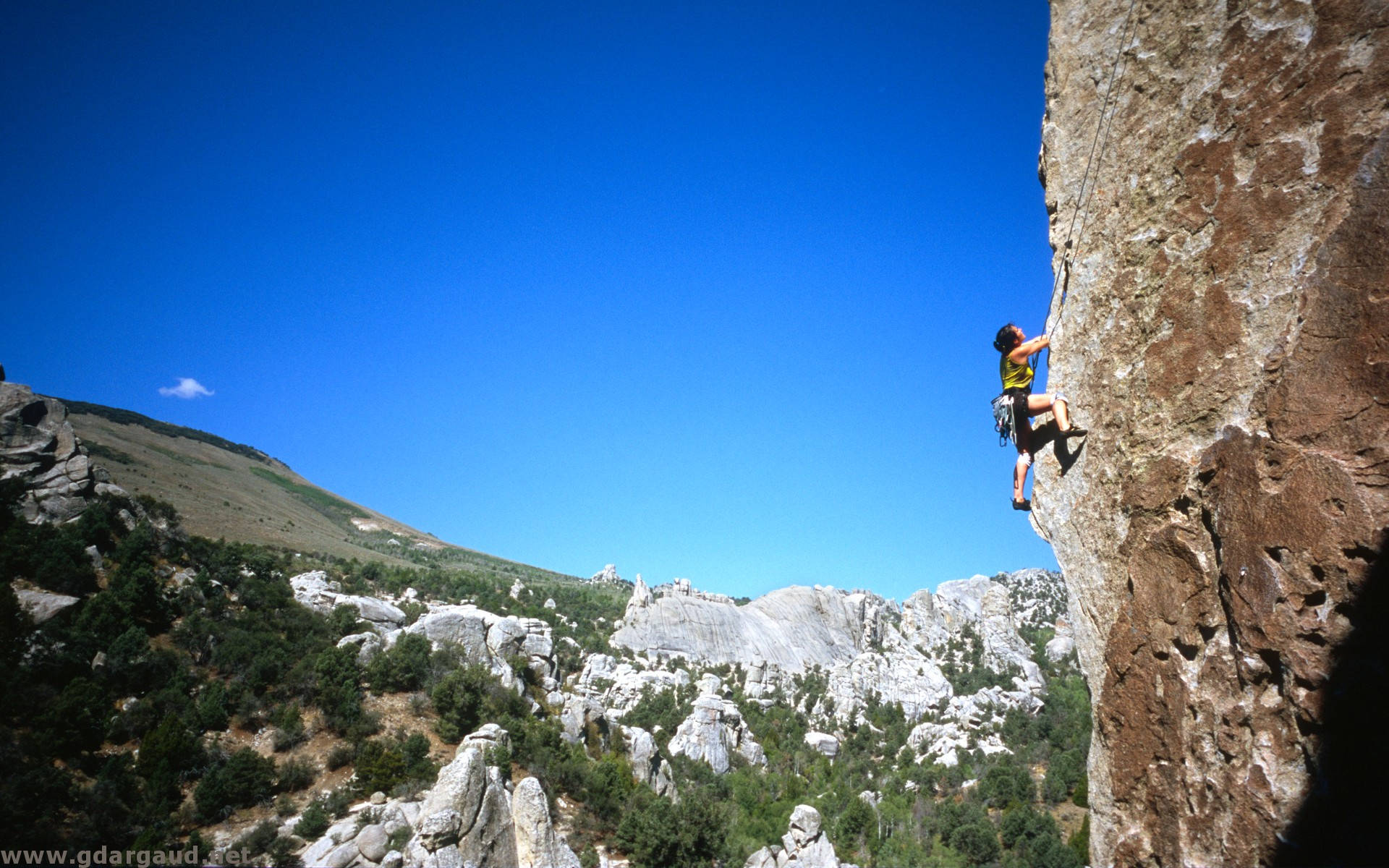 Girl Rock Climbing Over Rocky Mountain Background