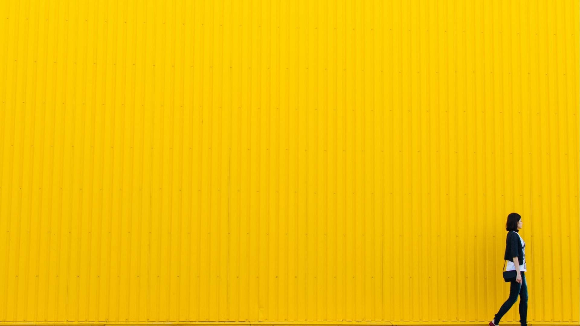 Girl Walking Through Neon Yellow Wall