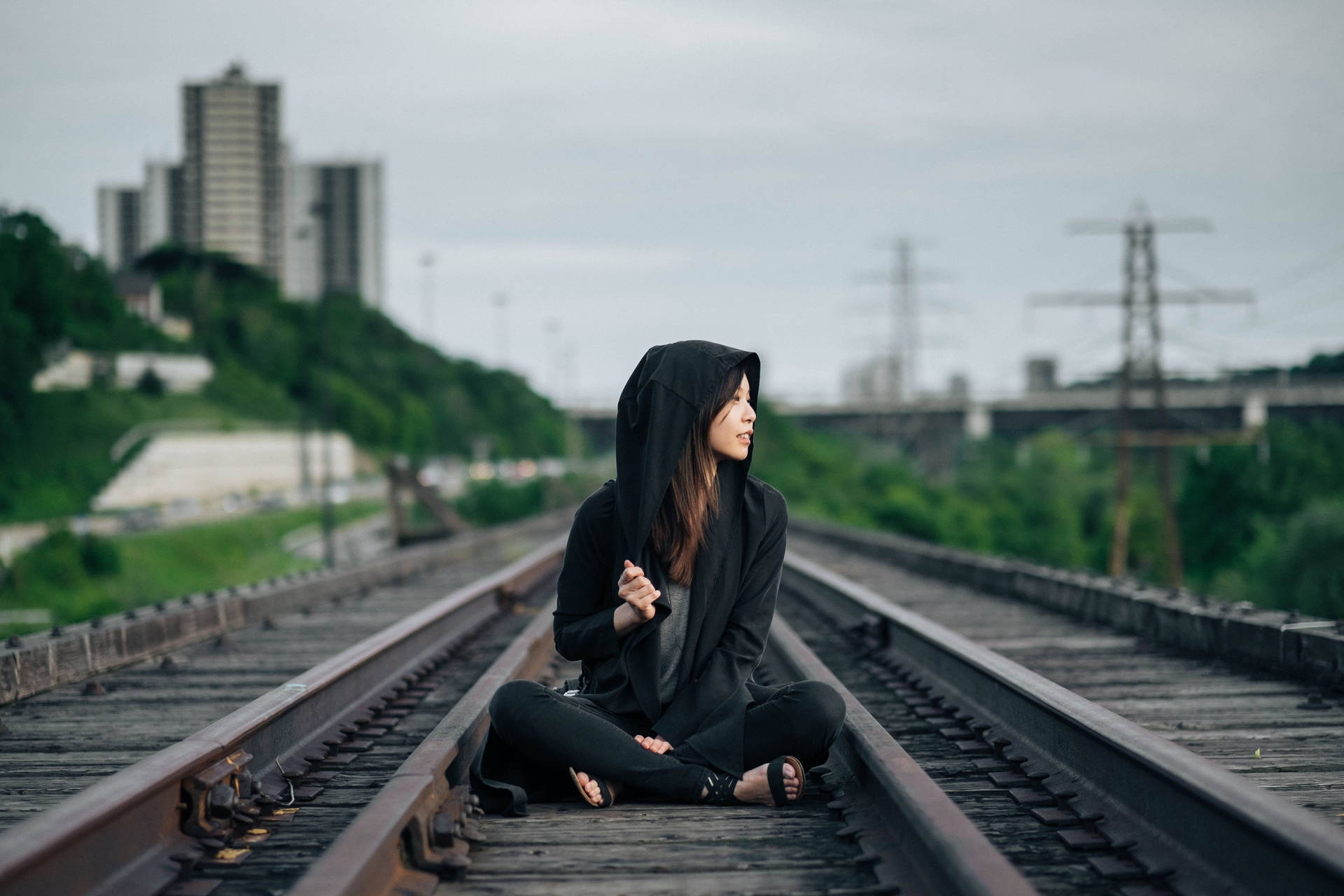 Girl Wearing Hoodie On Train Tracks Background