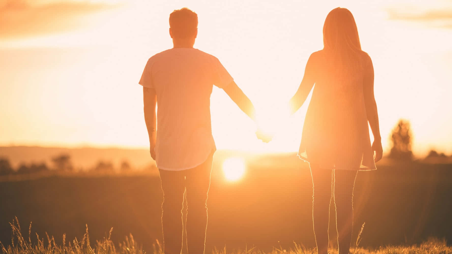 Girlfriend And Boyfriend Holding Hands During Sunset Background
