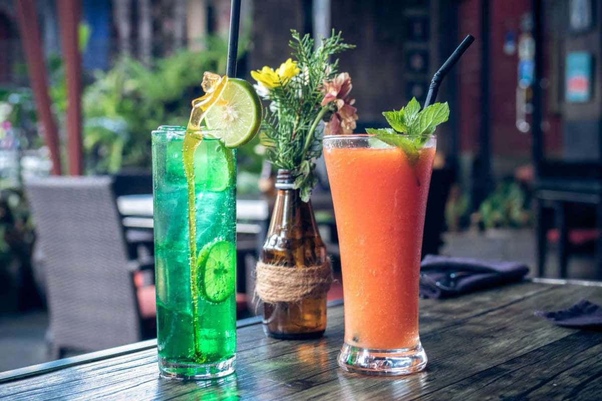 Glasses Of Drinks With Flower Vase Background