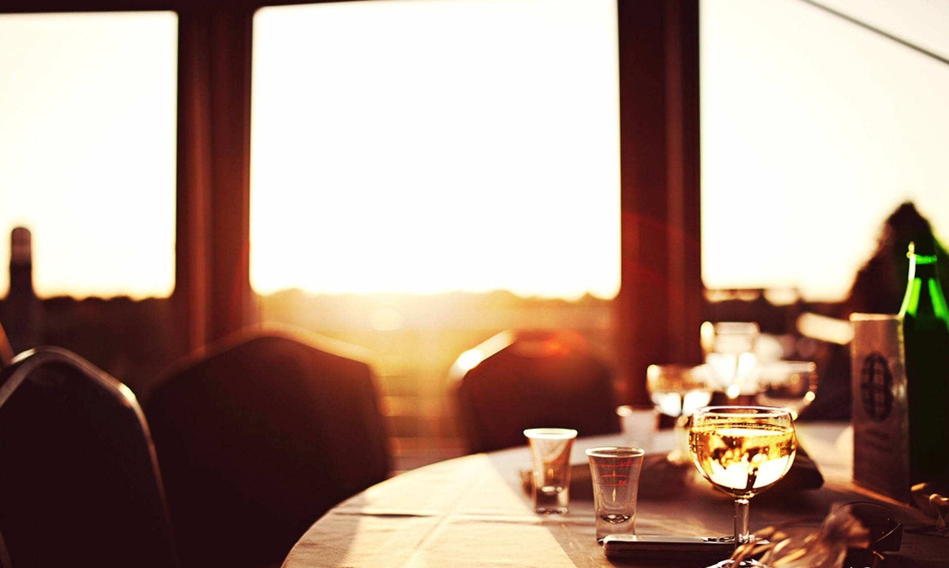 Glasses On Restaurant Table During Golden Hour Background