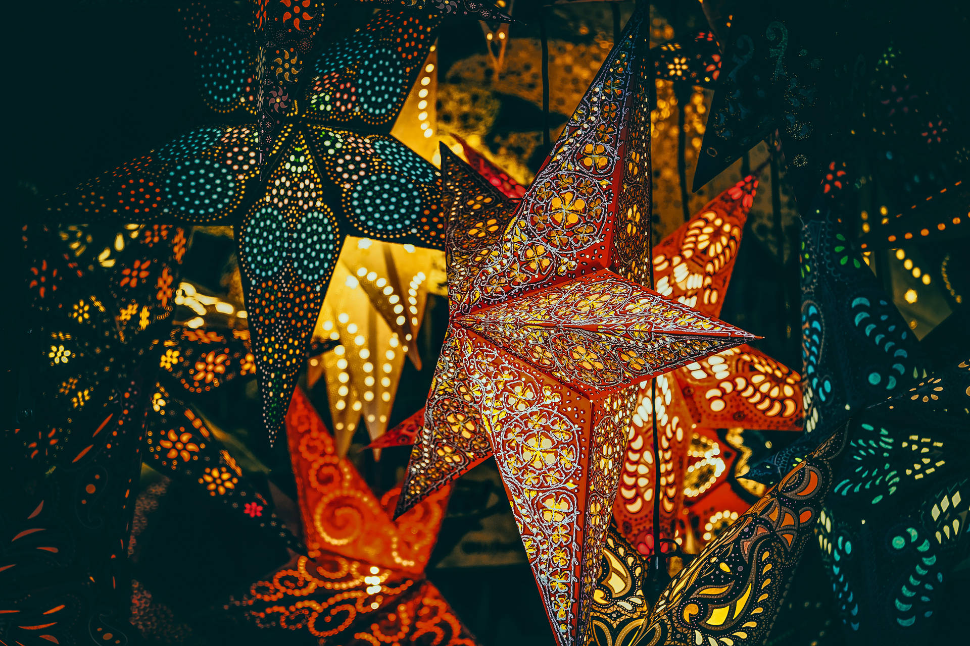 Glowing Christmas Star Lanterns On A Mistletoe Decked Desktop Background