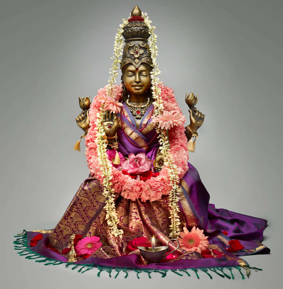 Goddess Mahalakshmi Statue Adorned With Flowers Background