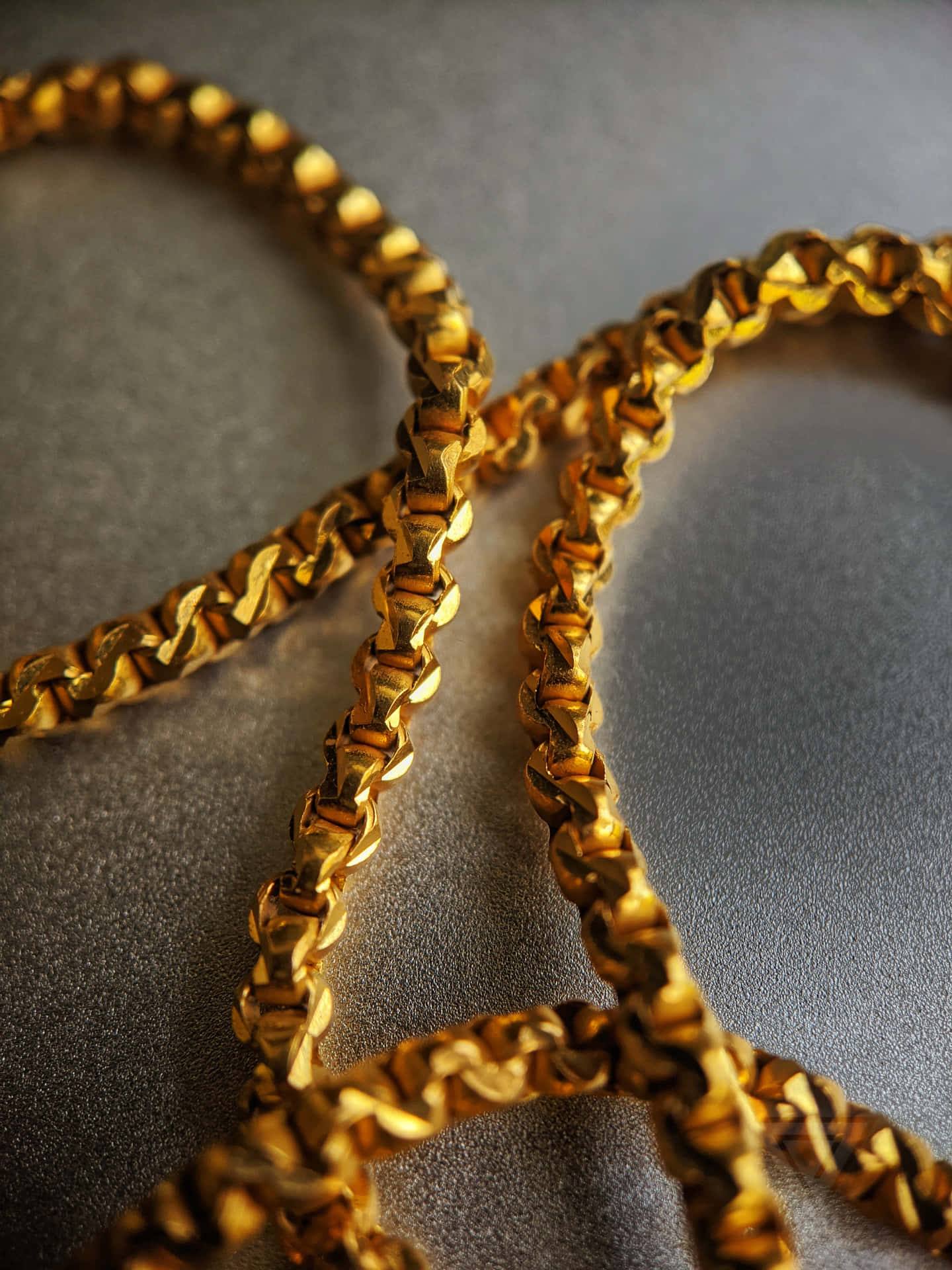 Gold Chain On A Silver Surface Background