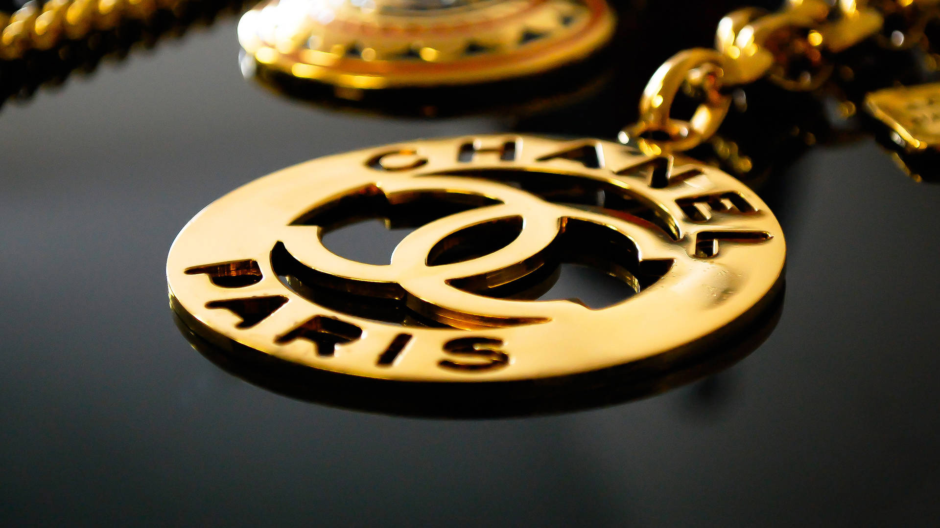 Gold Chanel Logo Pendant Background