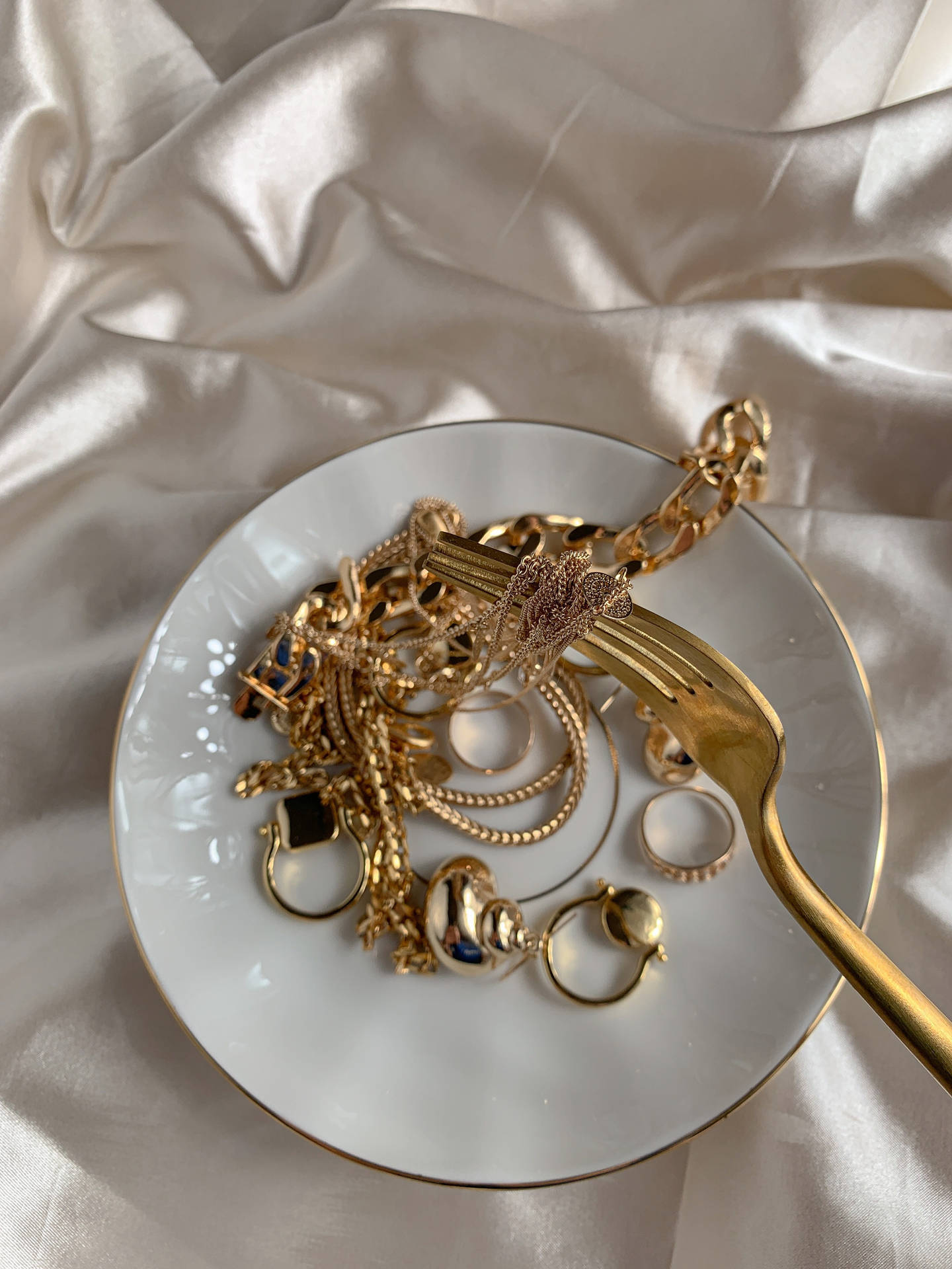 Gold Jewellery On A Plate Background