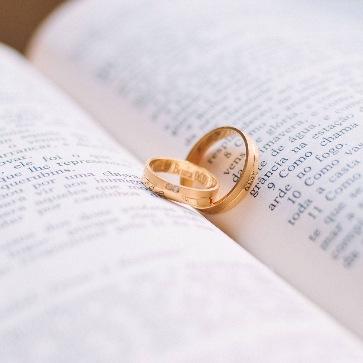 Gold Wedding Rings On Book Background