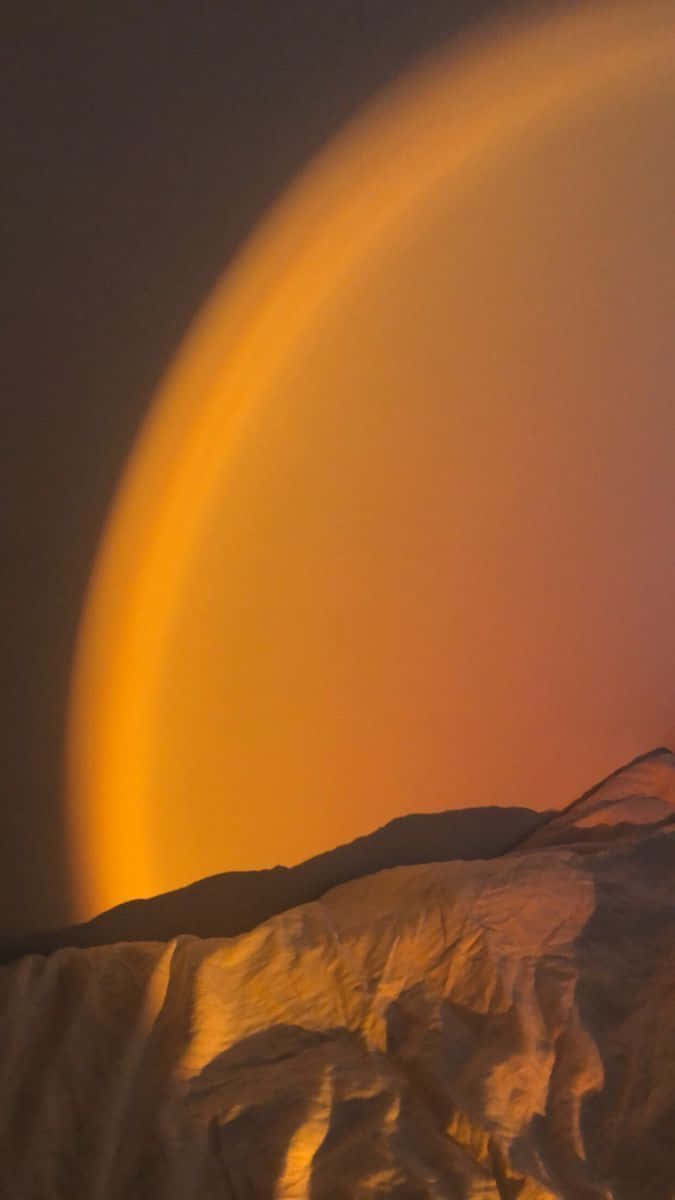 Golden Arch Glow Over Mountains Background