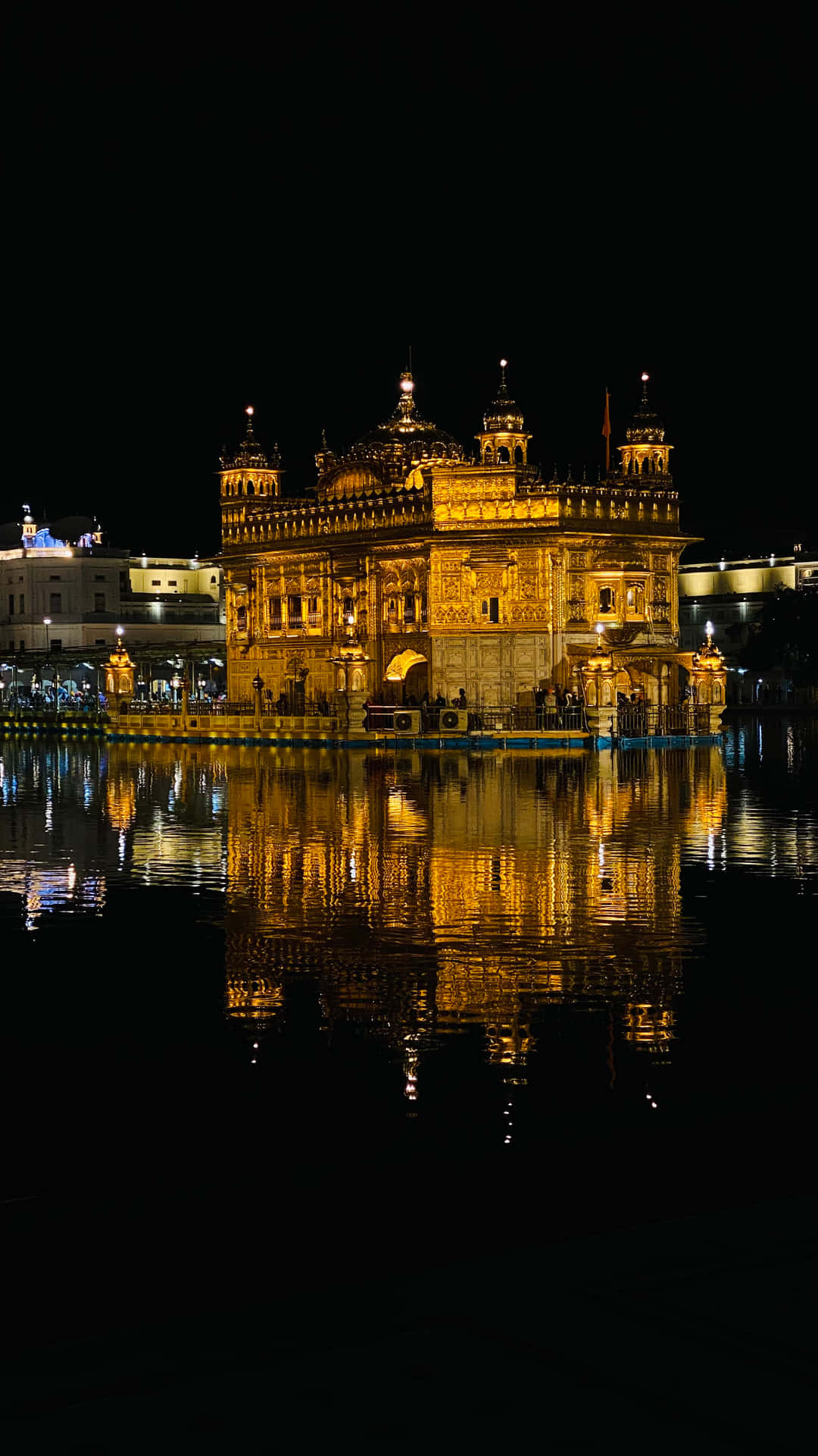 Golden Temple Lit Up At Night Background