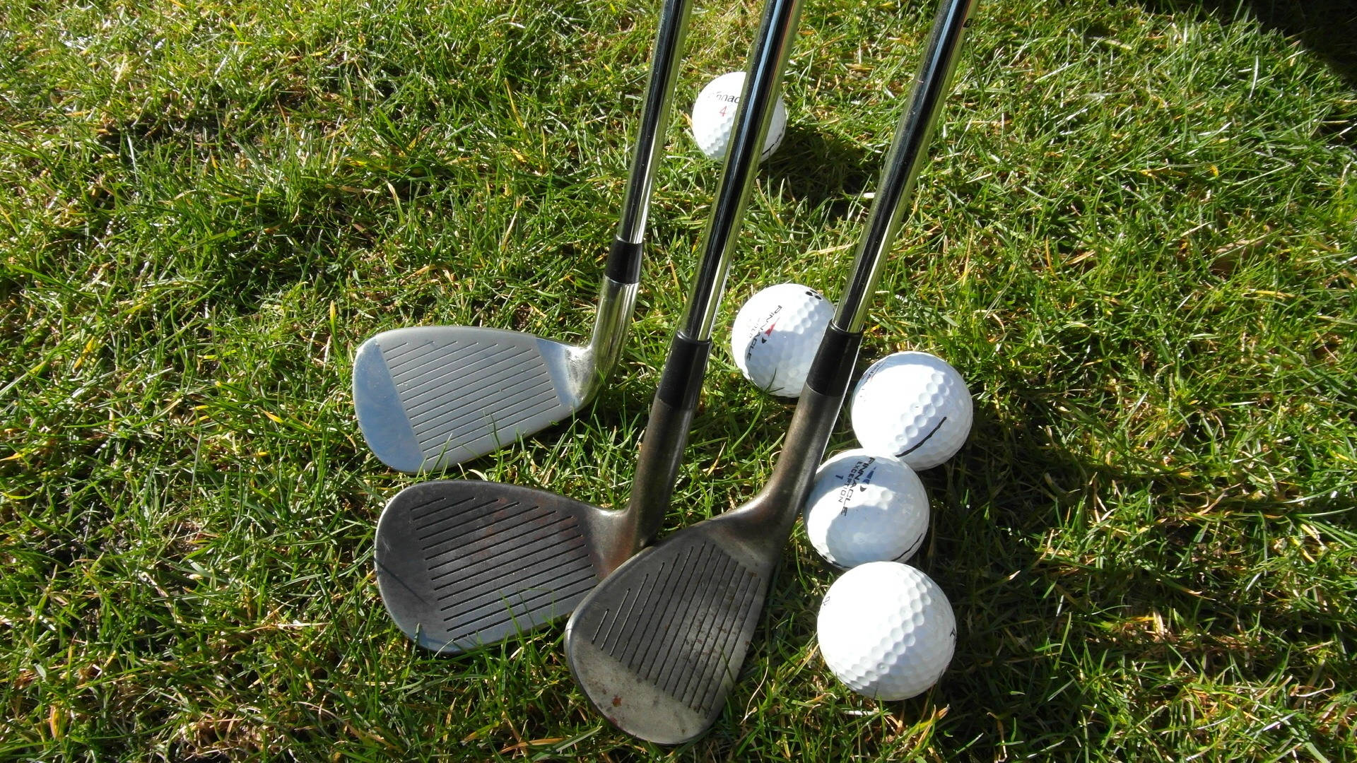 Golf Club Heads And Balls On Golf Course Background