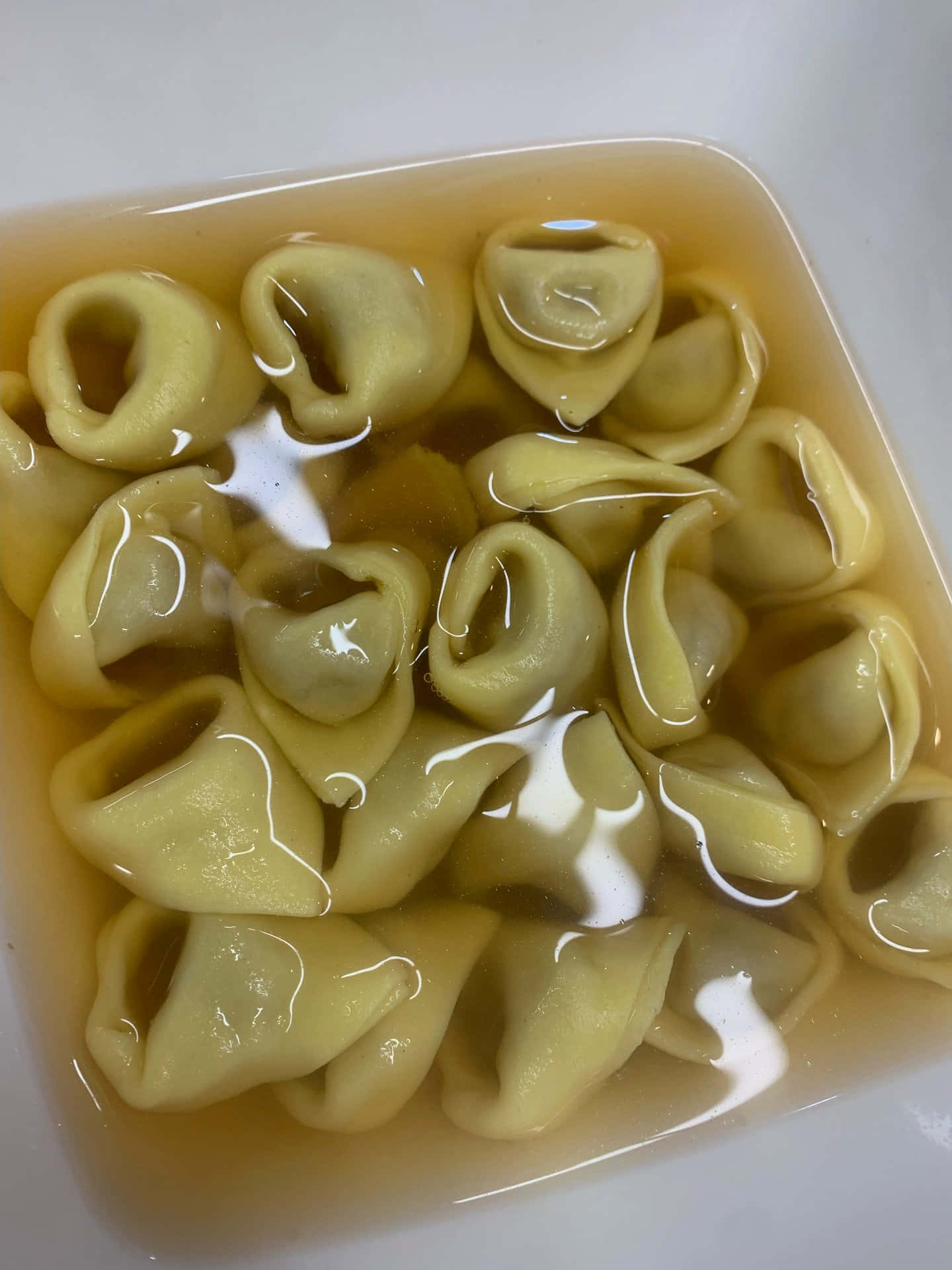 Gourmet Tortellini In Brodo In A Square Bowl Background