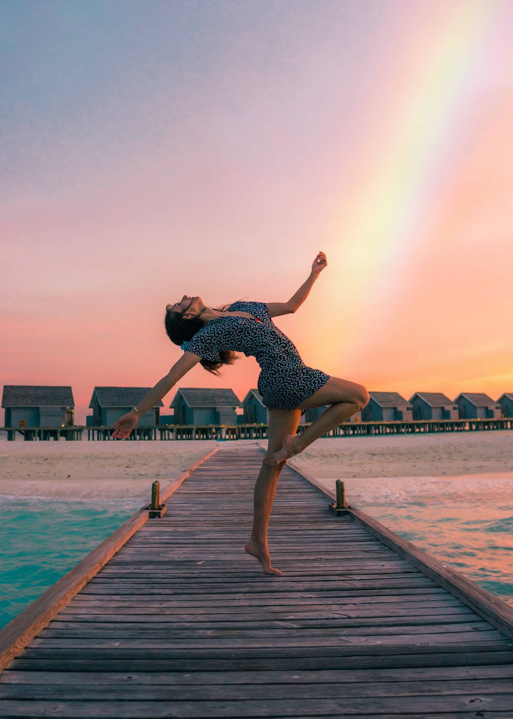 Graceful Dance Duet Overlooking A Rainbow Ocean View Background