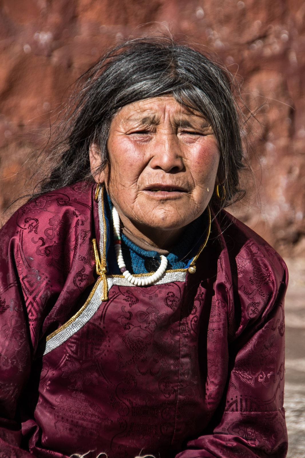 Graceful Elegance - A Beautiful Older Woman In A Fashionable Red Outfit Background