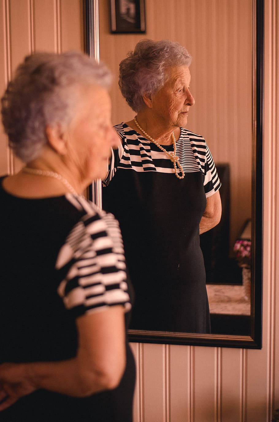 Graceful Elegance Reflected: A Stunning Older Woman Background