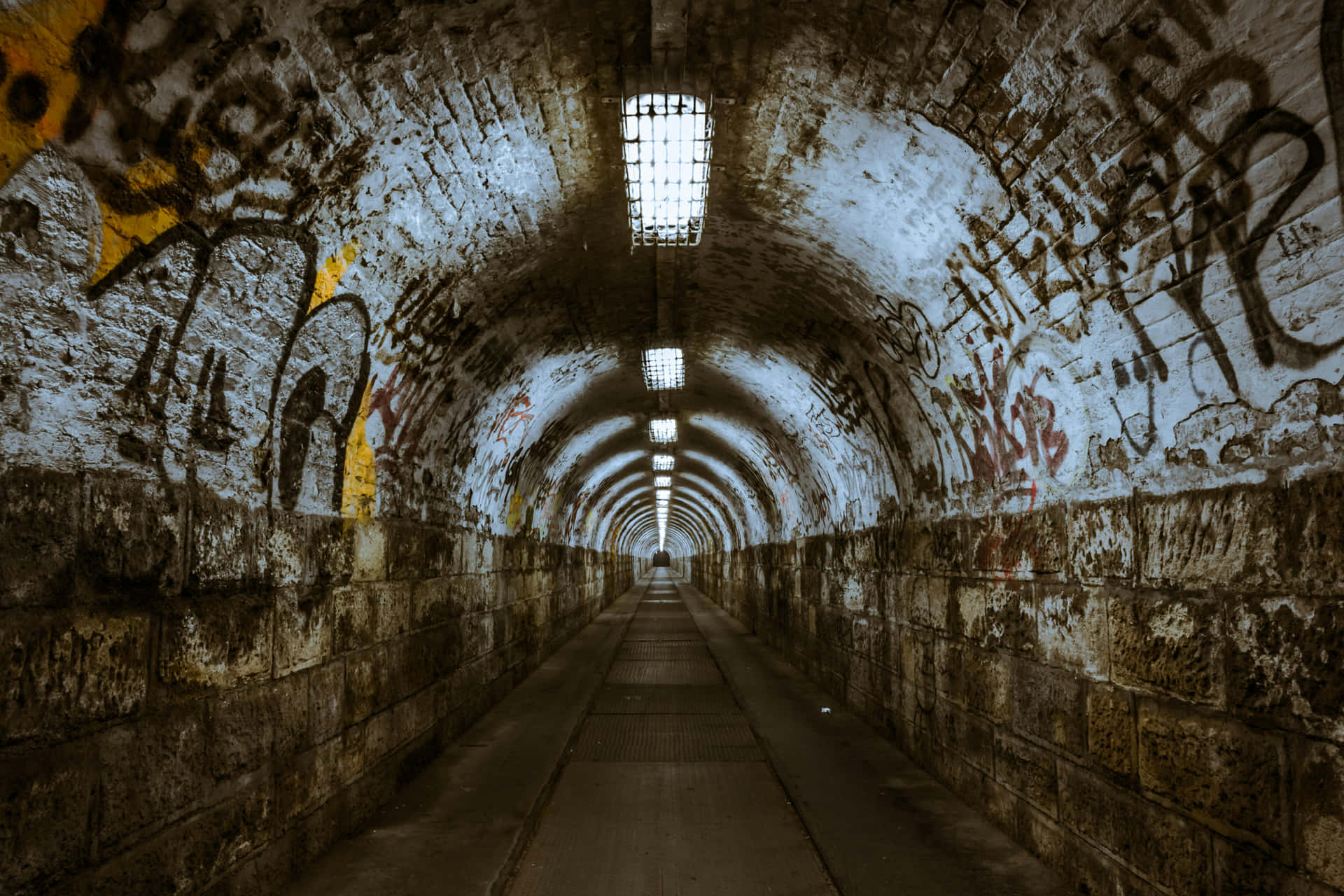 Graffiti Adorned Tunnel With Lights Background