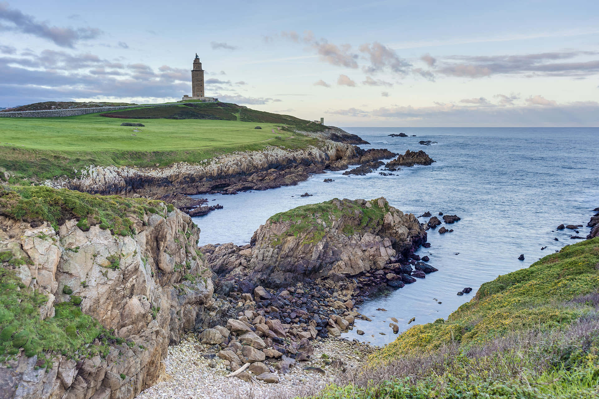 Grassy Green Landscape Around The Tower Of Hercules Background