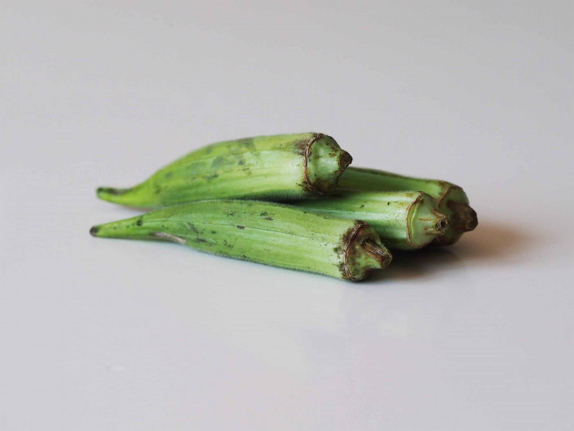 Green Okra On White Table Background