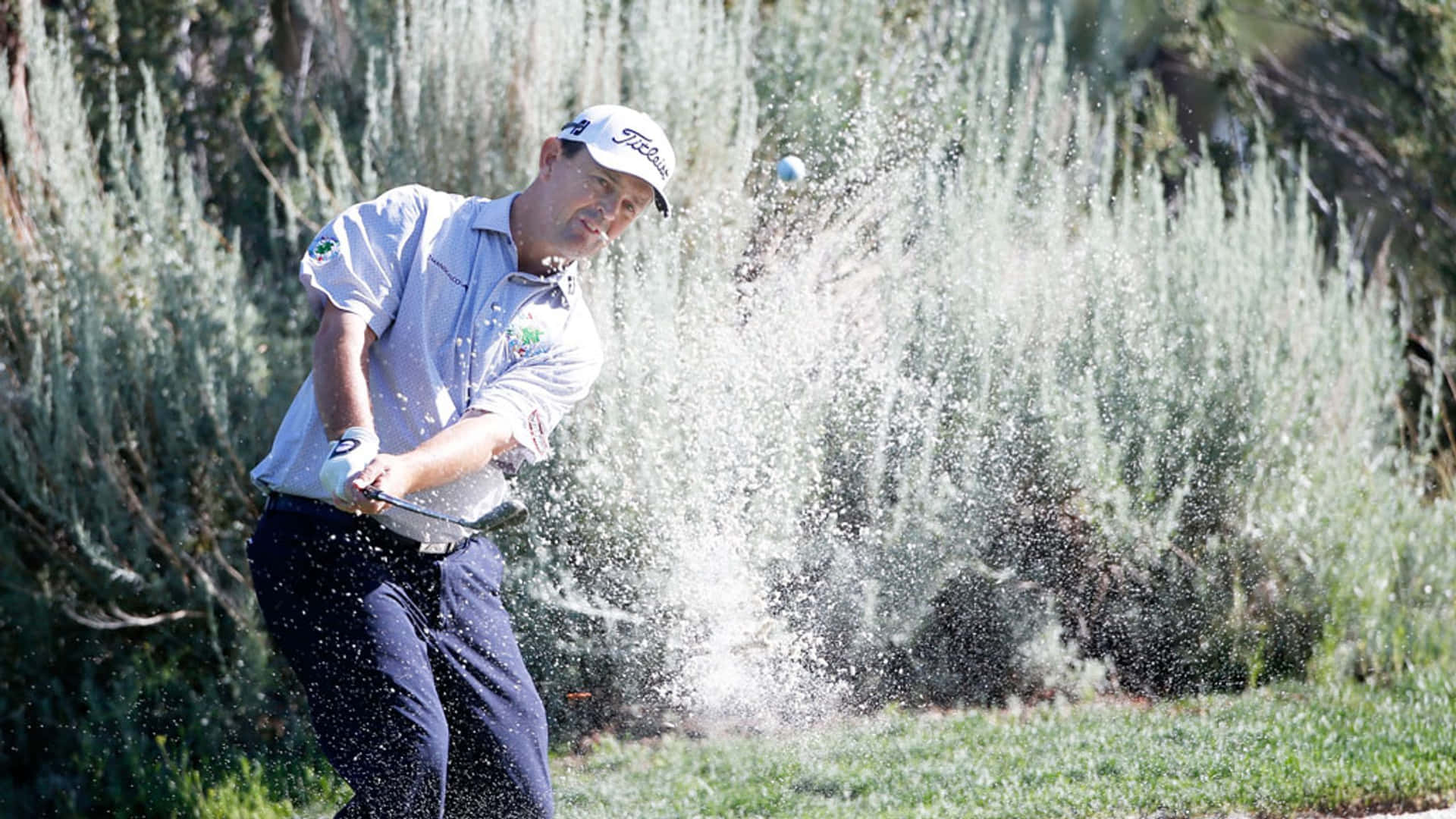 Greg Chalmers Hitting Ball With Sand Background